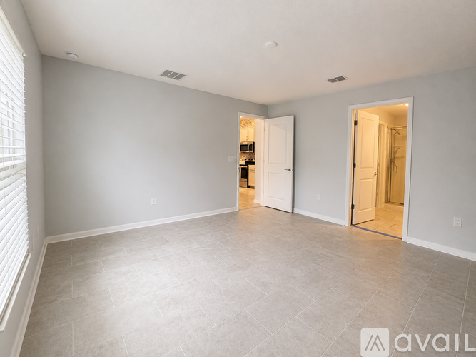 A spacious room with a tiled floor and two open doors.