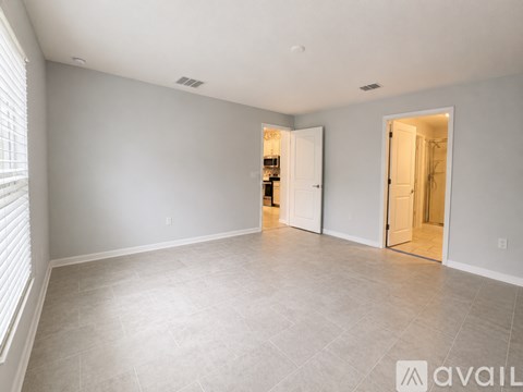 A spacious room with a tiled floor and two open doors.