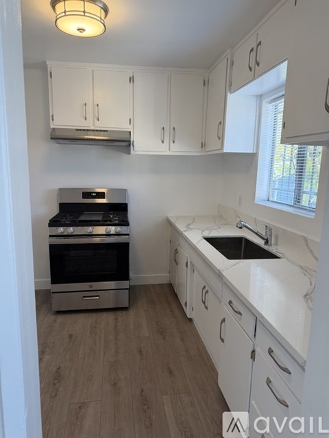 A kitchen with white cabinets and a stainless steel oven.