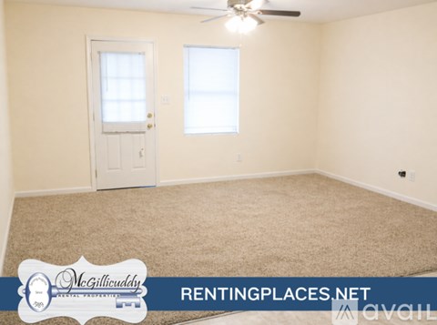 A room with a carpet floor, a ceiling fan, and a door with a window.