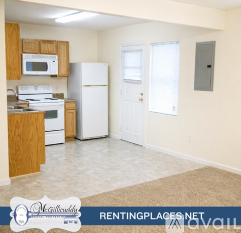 A kitchen with white appliances and wooden cabinets.
