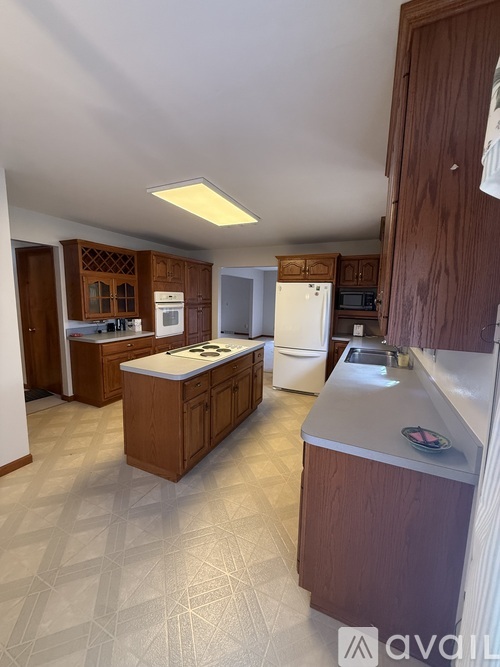 A kitchen with wooden cabinets and a white refrigerator.