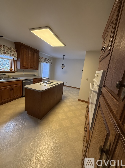 A kitchen with wooden cabinets and a tiled floor.