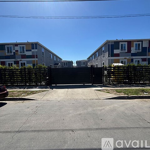 A black gate blocks the entrance to a row of townhouses.