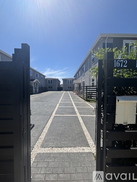 A sunny day at the entrance of a residential area with house numbers displayed.