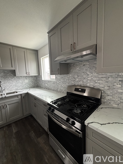A kitchen with a black stove top oven and white cabinets.