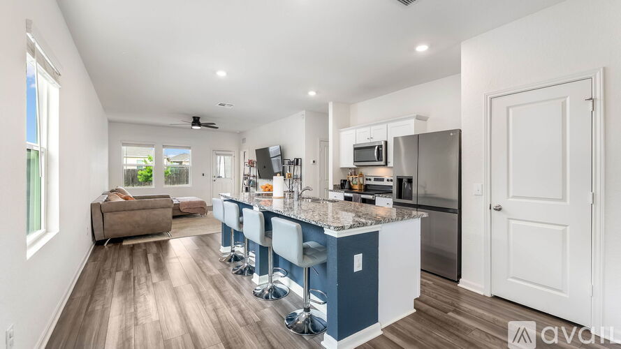 A modern kitchen with blue cabinets and a wooden floor.