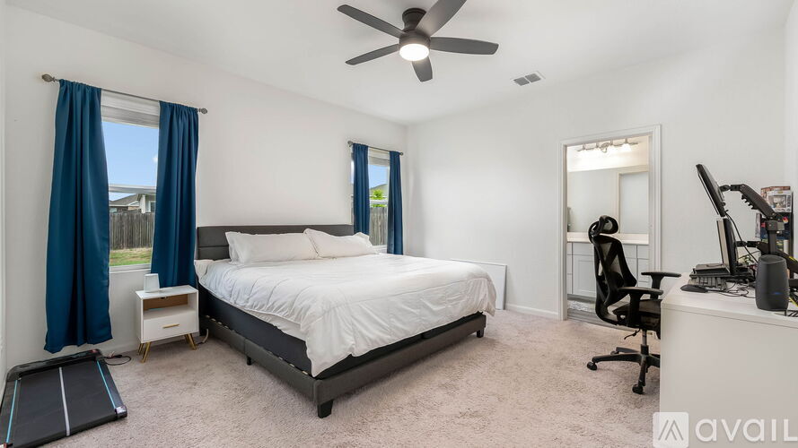 A bedroom with a bed, desk, and chair.