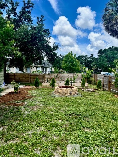 A backyard with a fence and a fire pit.