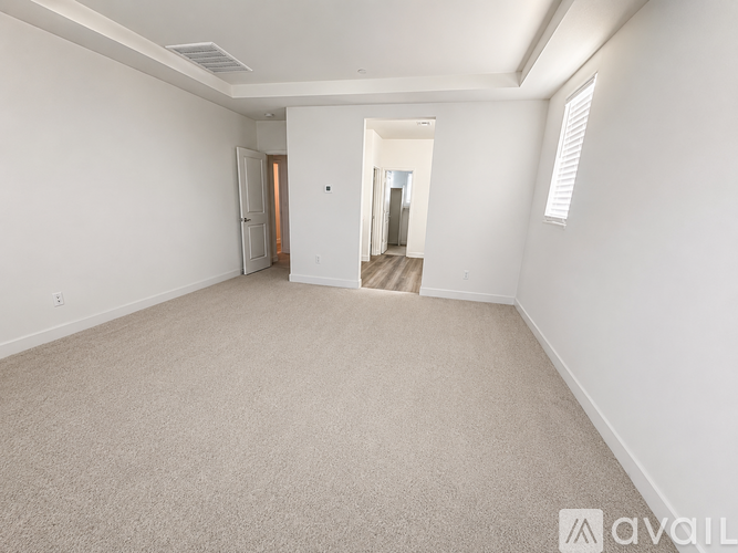 A spacious room with carpeted floor and white walls.