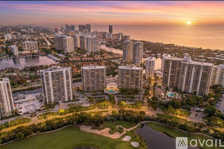 A cityscape with a sunset in the background and a park in the foreground.