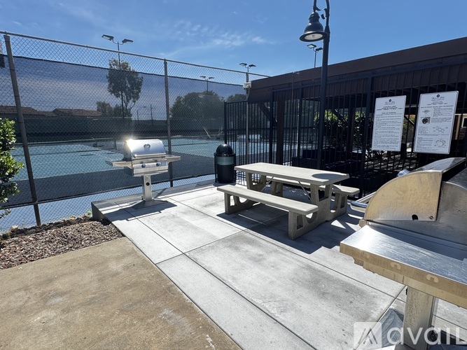 A poolside area with a picnic table and a fence.