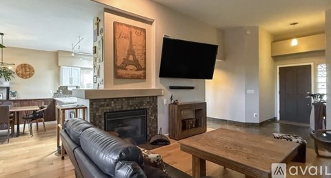 A living room with a fireplace and a painting of the Eiffel Tower.