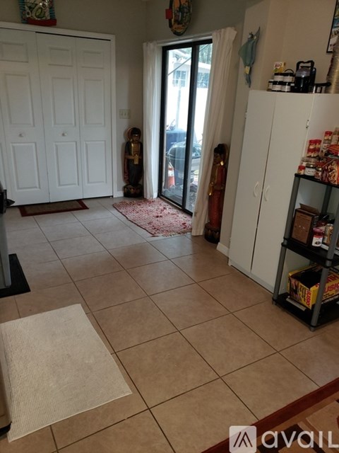 A room with a white door and a white cabinet with a shelf.