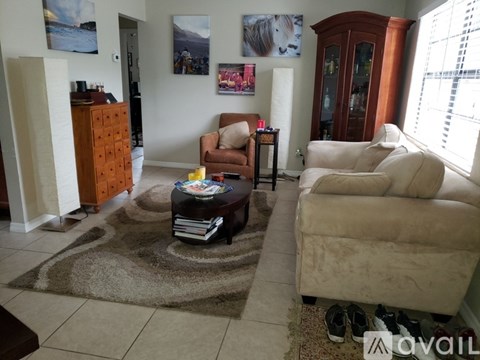 A living room with a brown chair and a brown cabinet.