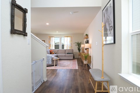 A living room with a grey sofa and a wooden floor.