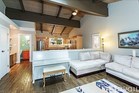 A living room with a white couch and a wooden bench.
