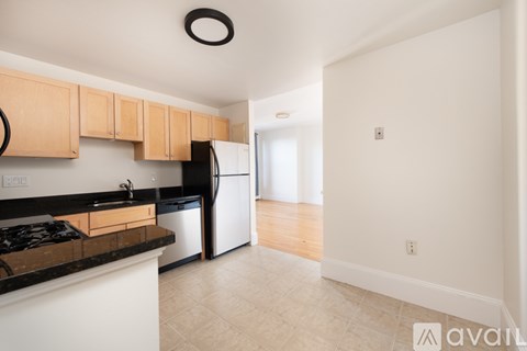 A kitchen with a black stove top oven and white cabinets.