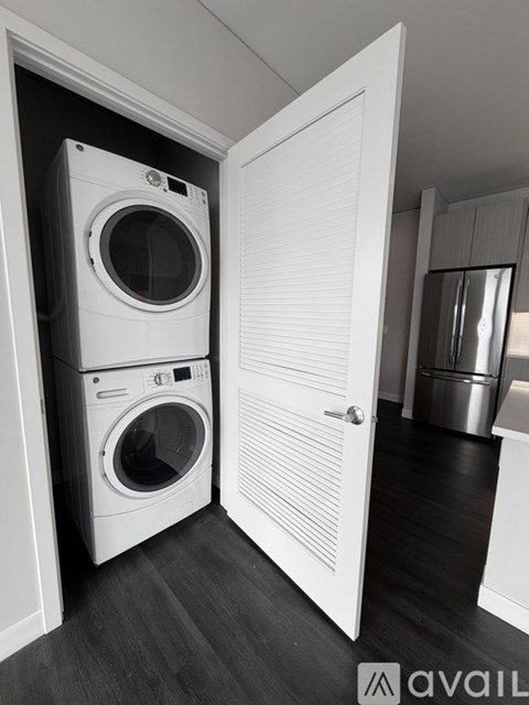 A black and white photo of a laundry room with a washer and dryer in it.