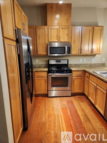 A kitchen with wooden cabinets and a stainless steel refrigerator.