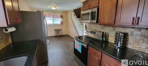 A kitchen with black countertops and wooden cabinets.