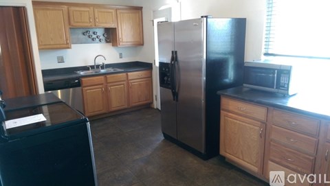 A kitchen with wooden cabinets and black appliances.