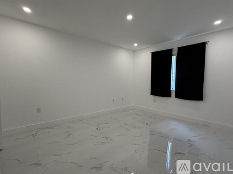 A room with a marble floor and a window with black blinds.