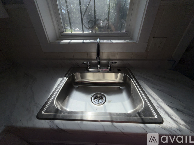 A modern kitchen sink with a window above it.