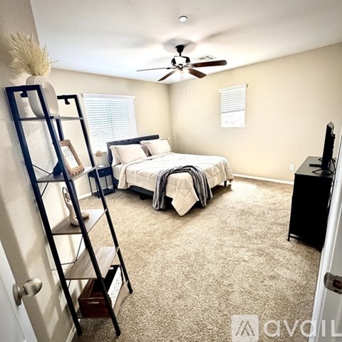 A bedroom with a bed, a television, and a ladder.