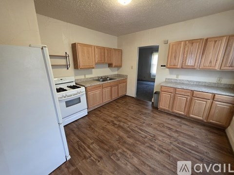 A kitchen with wooden cabinets and a white refrigerator.