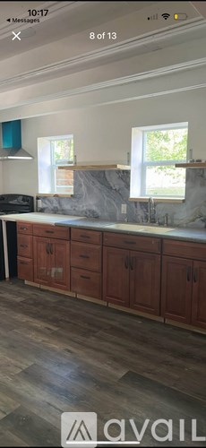 A kitchen with wooden cabinets and a marble countertop.