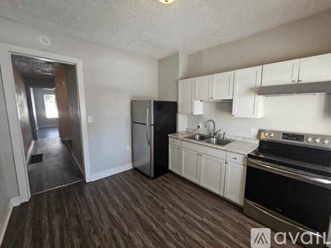 A kitchen with white cabinets and a black stove top oven.
