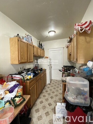 A kitchen with wooden cabinets and a checkered floor.