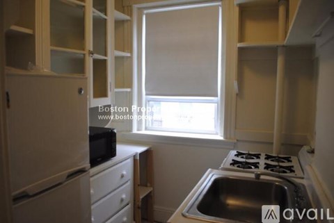 A kitchen with a stove top oven and a sink.