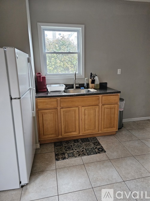 A kitchen with a white refrigerator and wooden cabinets.