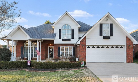 A white house with a black garage door is for sale.