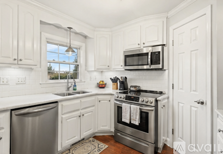 A kitchen with white cabinets and a stainless steel dishwasher.