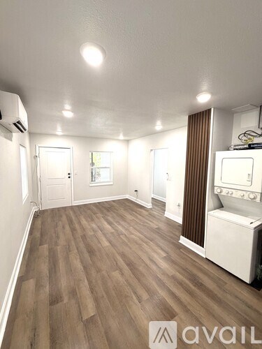 A room with wooden flooring and white walls.