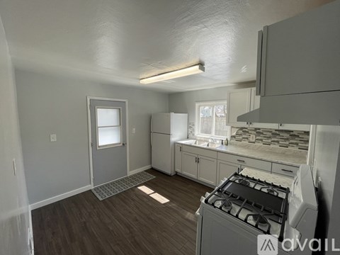 A kitchen with a stove, cabinets, and a window.