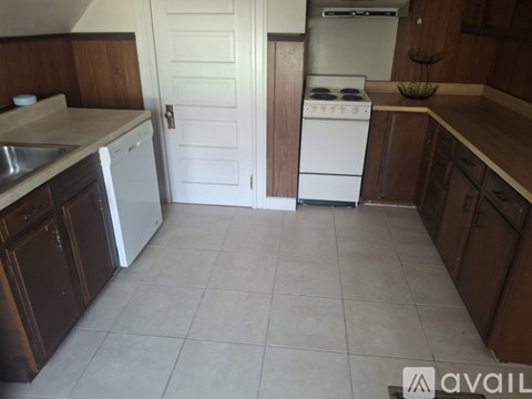 A kitchen with wooden cabinets and a white stove.
