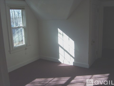 A room with a window and sunlight shining through.