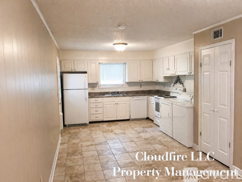 A kitchen with white appliances and cabinets, with a Cloudflare LLC Property Management watermark.