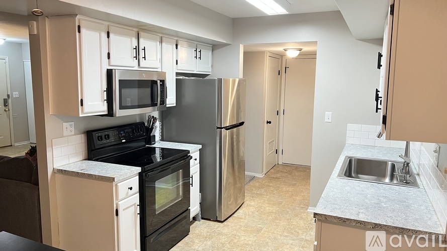 A kitchen with a black stove top oven and a black refrigerator.