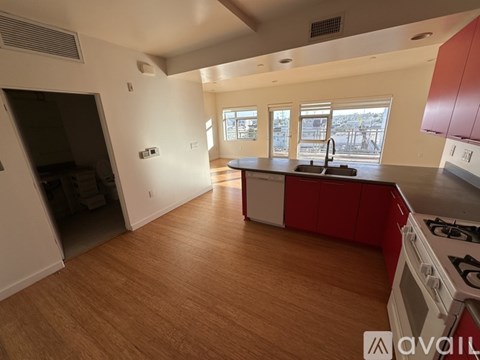 A kitchen with red cabinets and a white stove top oven.