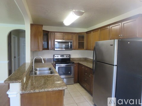 A kitchen with a granite counter top and stainless steel appliances.