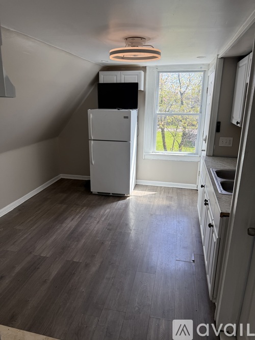 A kitchen with a refrigerator and a window.