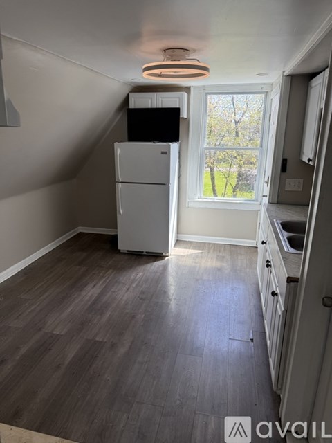 A kitchen with a refrigerator and a window.
