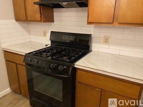 A black stove top oven in a kitchen with wooden cabinets.