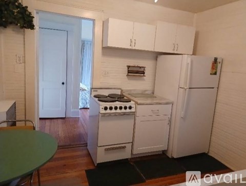 A kitchen with a white stove and refrigerator.