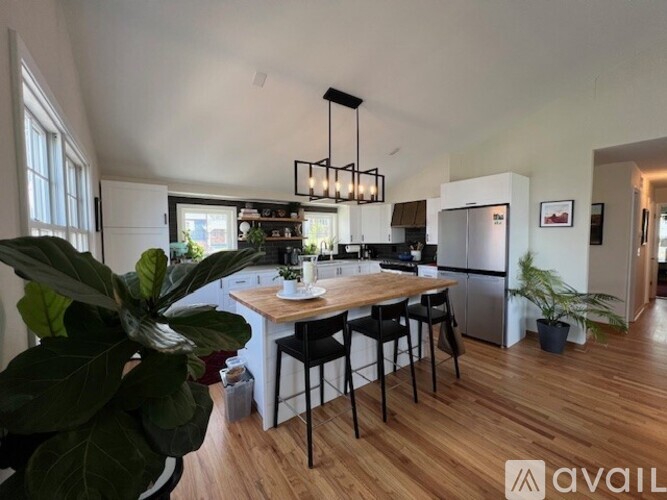 A modern kitchen with a wooden table and black chairs.